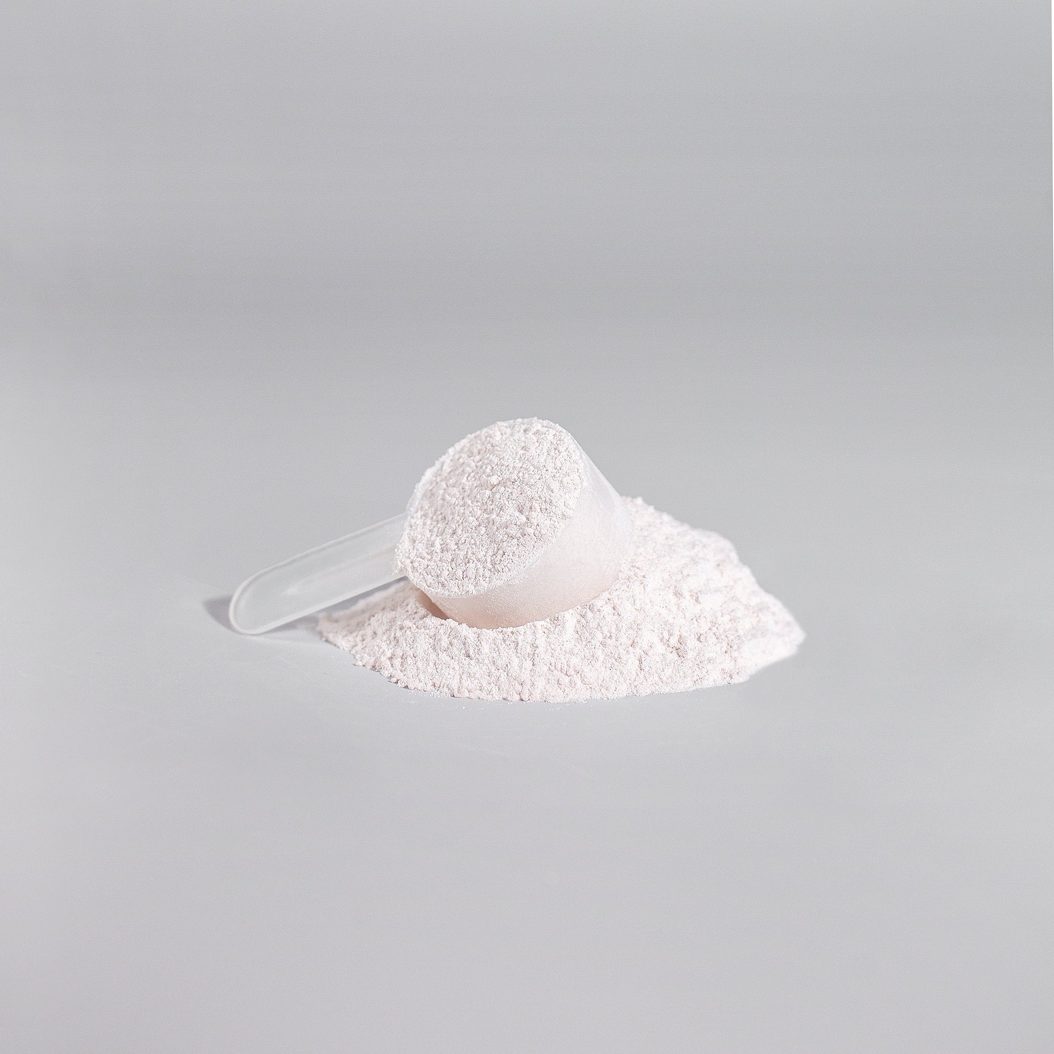 White powder in a scoop on a gray background